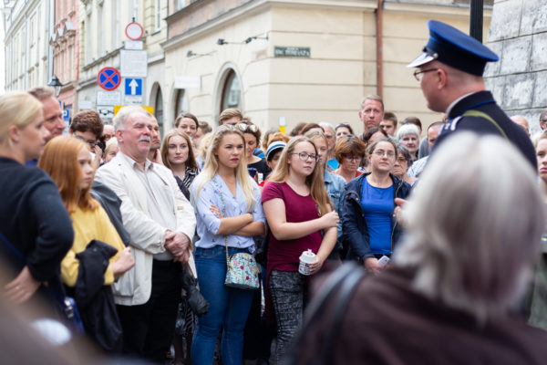 zdjęcie przedstawiające grupę ludzi słuchającą oprowadzającego